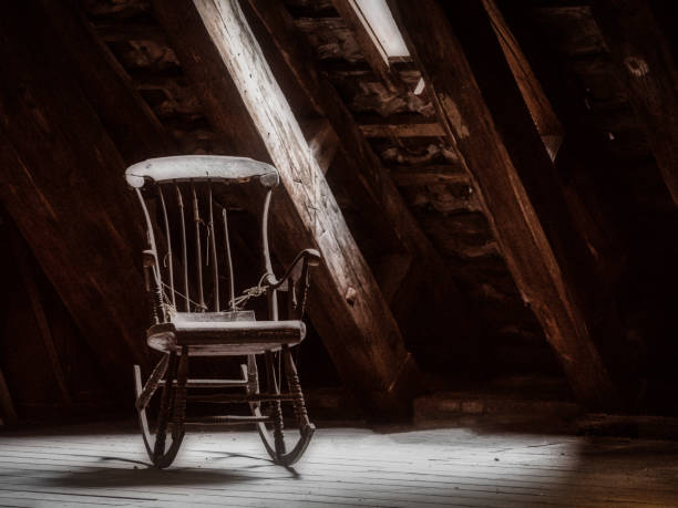 Old wooden rocking chair Old wooden rocking chair on a attic with a light beam through a window rocking chair stock pictures, royalty-free photos & images