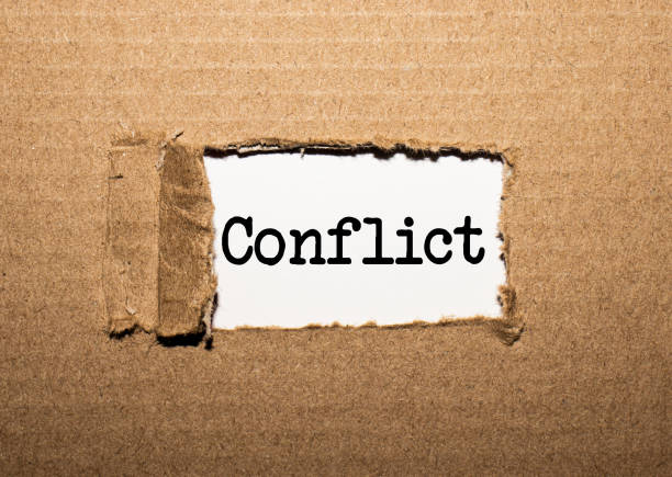 istock The text conflict. behind torn brown paper 1250315960