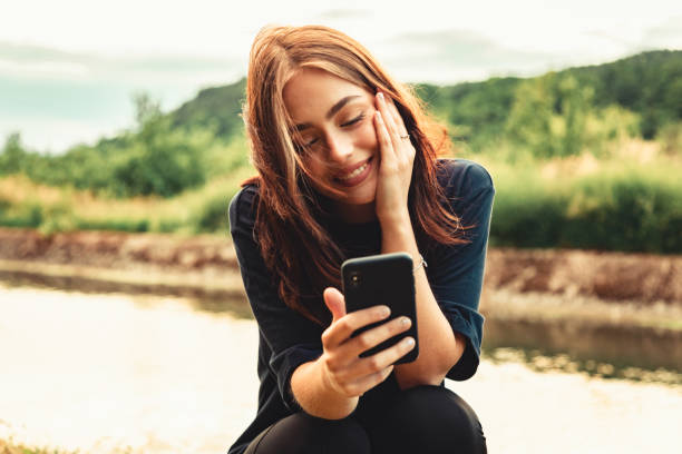 glück glück lächelnde junge frau auf video-anruf - mobile phone women telephone text messaging stock-fotos und bilder