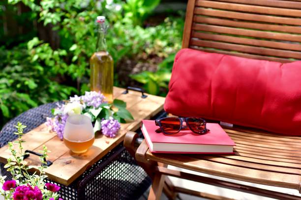assentos de pátio ao ar livre em jardim lindamente paisagístico na tarde quente de verão para relaxamento e atenção plena em pequeno espaço de espaço privado quintal - glass bar relaxation red - fotografias e filmes do acervo