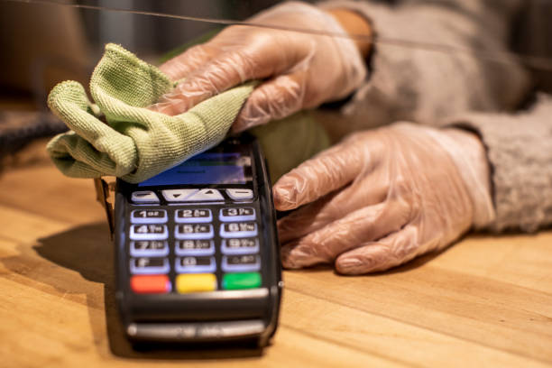 Close up on hands cleaning credit card reader. stock photo
