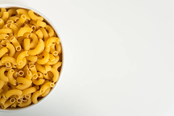 istock Raw dry uncooked Elbow Macaroni pasta spaghetti on white background. Good for basil tomato pesto sauce Homemade fresh Italian food organic whole wheat vegan spaghetti noodle for a healthy meal 1250328883