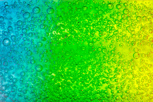 Abstract textured background transparent blue, green and yellow gel. Soft focus.