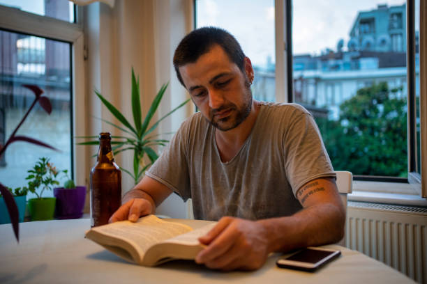 istock man reading with beer in home 1250328996