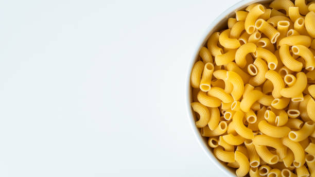istock Raw dry uncooked Elbow Macaroni pasta spaghetti on white background. Good for basil tomato pesto sauce Homemade fresh Italian food organic whole wheat vegan spaghetti noodle for a healthy meal 1250329150