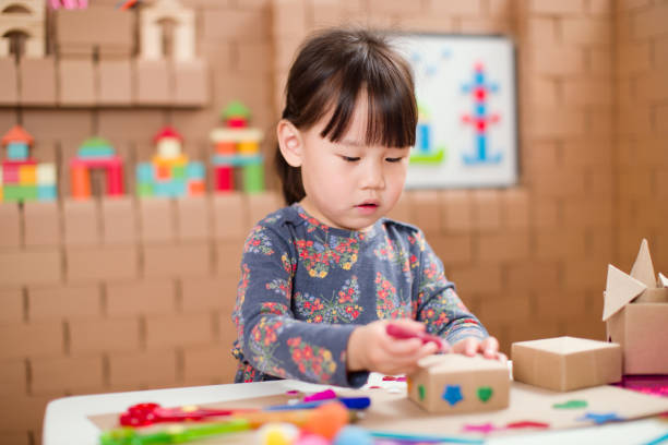 istock toddler girl  making craft by using cardboard for homeschooling 1250329198