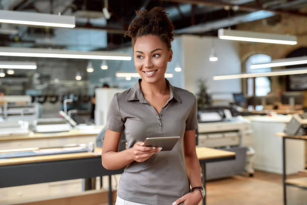 istock Hard Working and Learning. Attractive african american worker standing in office 1250329912