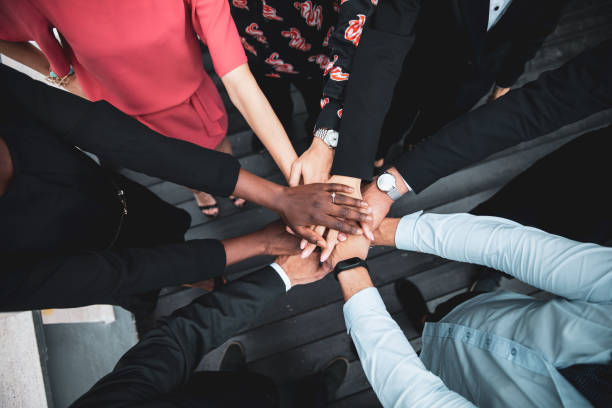 Partnership and teamwork is the key to the success Shot of human hands stuck on each other between business colleagues partnership racial equality stock pictures, royalty-free photos & images