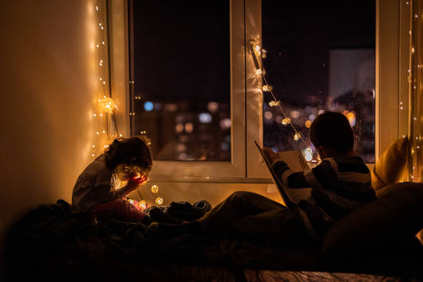 istock Cute little kids reading book during home quarantine 1250337703