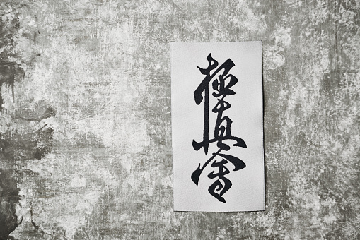 Calligraphy - Kyokushinkai karate symbol on wooden background.  \