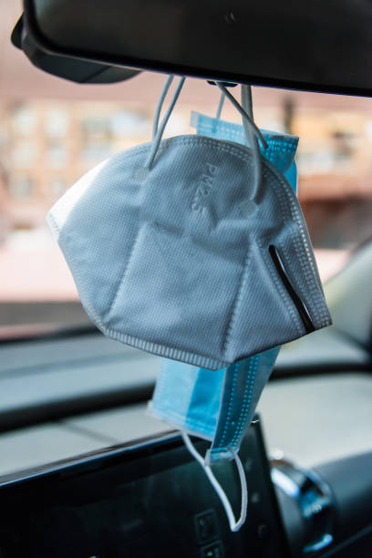 istock Face masks hanging in car interior mirror 1250343712