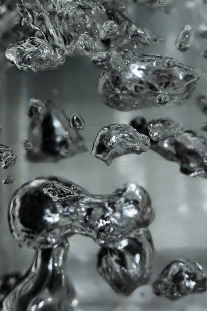 Drops and bubbles of mercury in water. Dangerous chemical element, the scientific experience. Drops and bubbles of mercury in water close-up. Dangerous chemical element, the scientific experience.  Defocused image, motion blur chromium element periodic table stock pictures, royalty-free photos & images