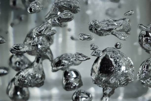 Drops and bubbles of mercury in water. Dangerous chemical element, the scientific experience. Drops and bubbles of mercury in water close-up. Dangerous chemical element, the scientific experience.  Defocused image, motion blur mercury metal stock pictures, royalty-free photos & images