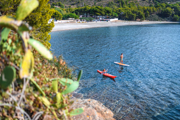 istock Paddleboarder and Kayaker Off Mediterranean Coastline 1250348464