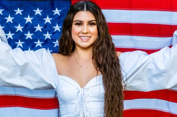 istock Smiling young woman holding a US flag 1250350512
