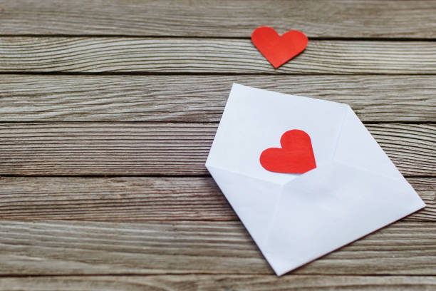 istock two red paper hearts on white open envelope against gray wooden background 1250351456