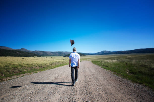 uomo che cammina da solo nella natura selvaggia di valles caldera, il cappello aleggia sopra - bizarre rear view hat blue foto e immagini stock