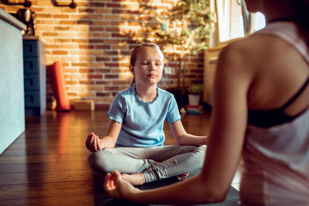 istock Mother and Daughter doing Yoga 1250357220