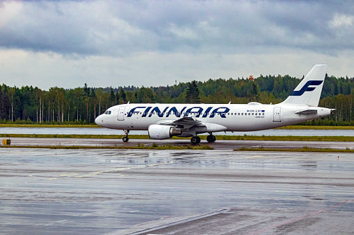 Helsinki, Finland - Aug 11, 2019: Finnair Airbus A320-214 OH-LXF preparing to depart or just landed at Helsinki Vantaa Airport on a cold, wet overcast August day.