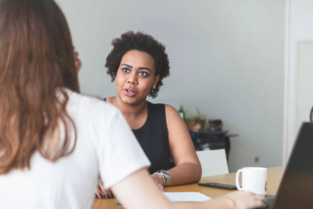 istock Two young women talking in an office. 1250368577