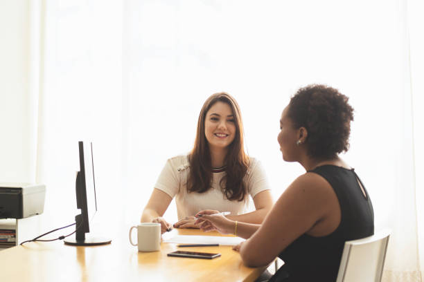 istock Two young women talking in an office. 1250368586