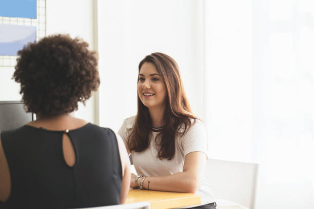 istock Two young women talking in an office. 1250368837