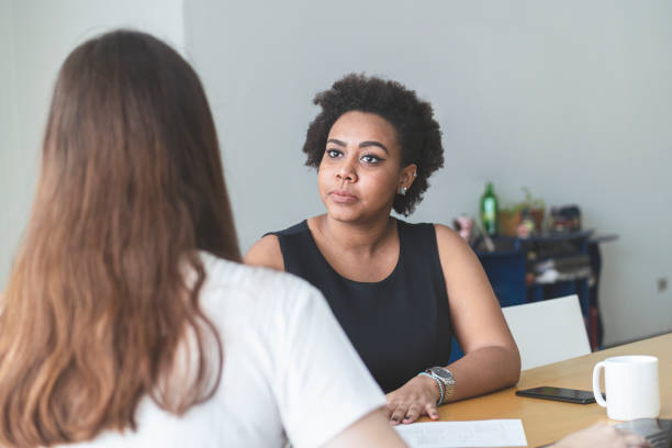 istock Two young women talking in an office. 1250368853