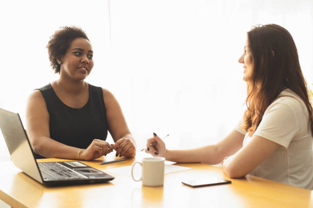 istock Two young women talking in an office. 1250368898