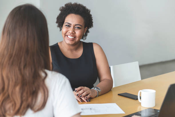 istock Two young women talking in an office. 1250369444