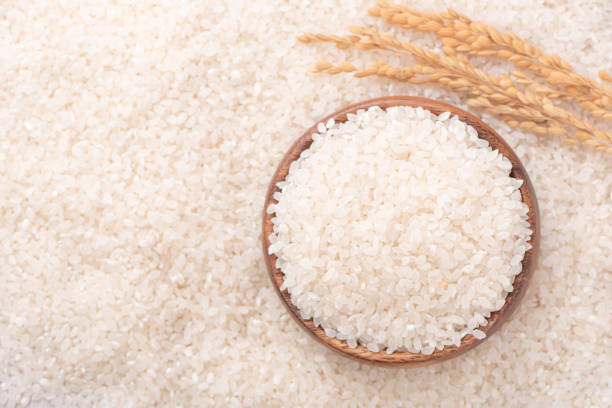istock Raw rice in a bowl and full frame in the white background table, top view overhead shot, close up 1250372073