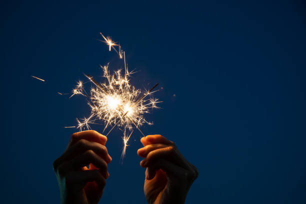 fogos de artifício pequenos - sparkler sparks new years eve human hand - fotografias e filmes do acervo