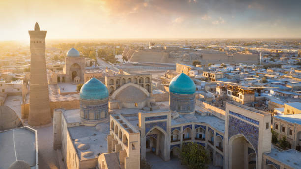 Bukhara Uzbekistan Sunset Panorama Buxoro Aerial View Sunset Panorama over the famous Kalyan Poi Kalon, Poi Kalan or Po-i-Kalyan and Kalon Mosque with courtyard in the old town of Bukhara - Buxoro - Бухорo. Aerial Drone Point View at Sunset. Itchan Kala, Bukhara, Khorezm Region, Uzbekistan, Central Asia. samarkand urban stock pictures, royalty-free photos & images