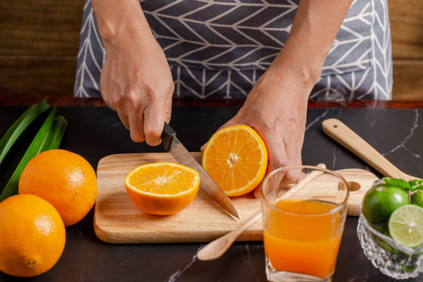 istock women cutting orange for make juice on kitchen table. 1250385195