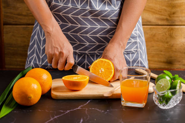 istock women cutting orange for make juice on kitchen table. 1250385201