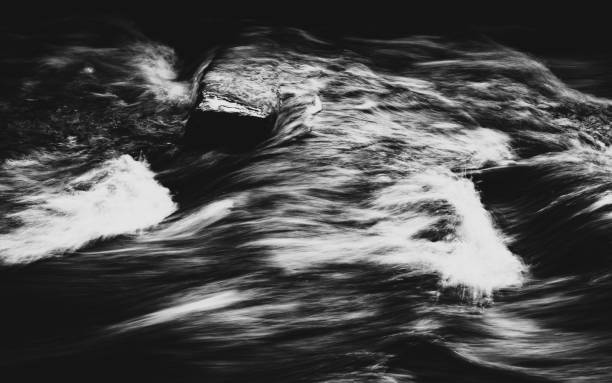 The Black and white photo of the texture of flowing water that creates anthropomorphic images in abstract ways.