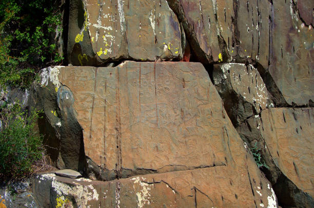 massif rocheux avec des dessins de personnes anciennes, pétroglyphes sur une pierre. - dolmen stone grave ancient photos et images de collection