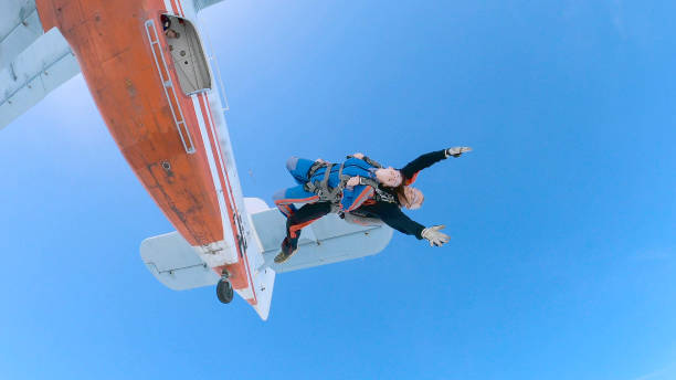 woman with instructor in free fall. - skydiving tandem parachute parachuting imagens e fotografias de stock