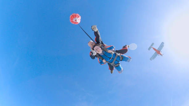 woman with instructor in free fall. - skydiving tandem parachute parachuting imagens e fotografias de stock
