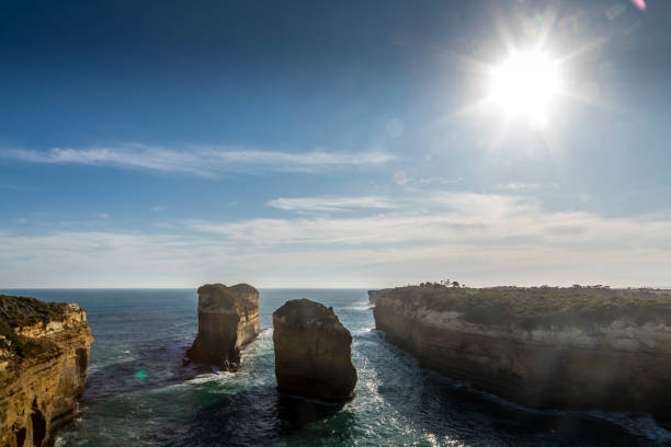 vista dalla great ocean road sulla costa vicino al london bridge a victoria, in australia, in una giornata di sole in estate. - formazioni calcaree london arch foto e immagini stock