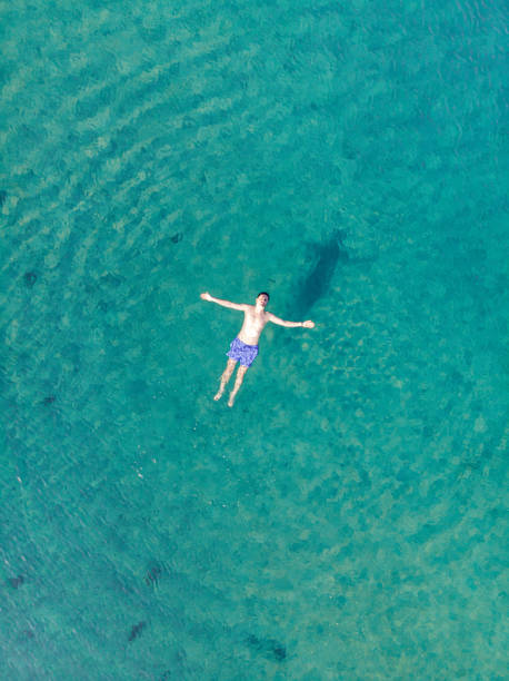 istock Aerial View Man Floating in Water and Relaxing 1250396015
