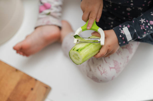 istock Toddler girl peeling cucumber 1250396024