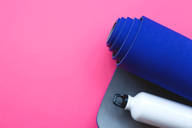 istock Bright blue yoga mat on a pink background 1250397788
