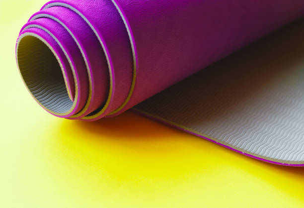 istock Bright purple yoga mat on a yellow background 1250397801