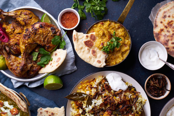 Indian cuisine dinner: tandoori chicken, biryani Indian cuisine dinner: tandoori chicken, biryani, red lentil curry dal with rice naan, palak paneer and basmati rice on dark concrete background masala stock pictures, royalty-free photos & images