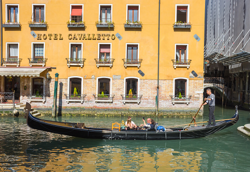 Venice, Italy - April 20, 2019: gondolas in front of Hotel Cavalletto in a beautiful sunny day.