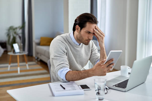 istock Worried businessman using digital tablet while working at home. 1250400673