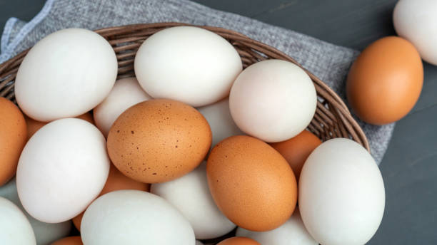 istock Chicken egg and duck egg on a black wooden table. 1250403028