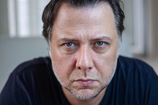 Close-up portrait of middle-aged man is looking at the camera. Horizontal composition with copy space.