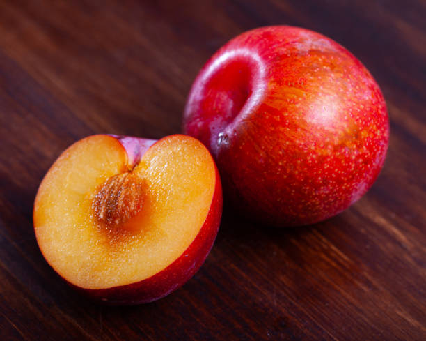 istock Whole and halved ripe red plums 1250403932
