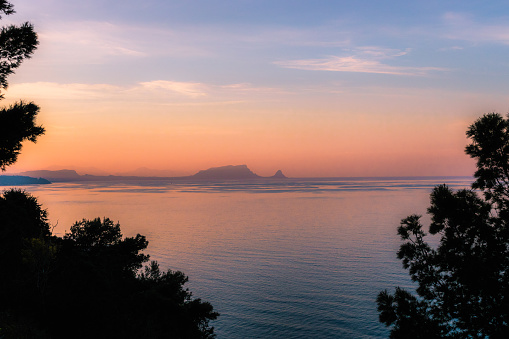 Capo Zaffarana seen from the Belvedere of Termini Imerese at sunset with some trees in forground